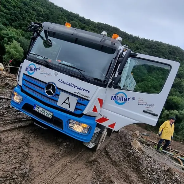 Abscheiderservice-Lkw von Müller auf schlammigem, zerstörtem Untergrund im Ahrtal