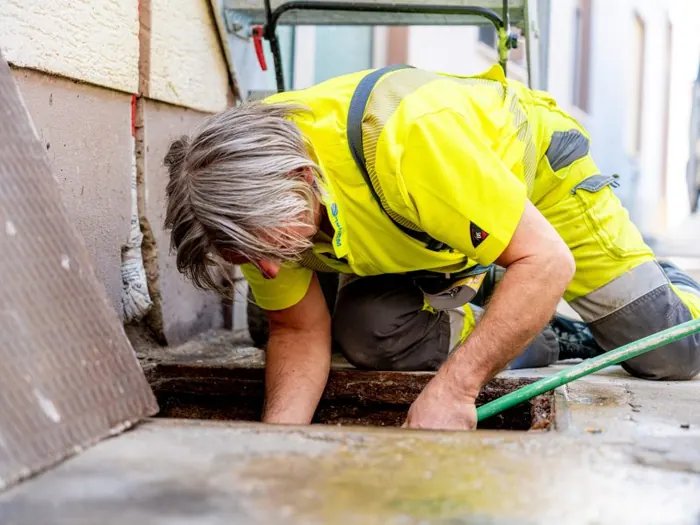 Mitarbeiter arbeitet an einem geöffneten Schacht